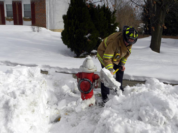 Firefighter shoveling snow from hydrant