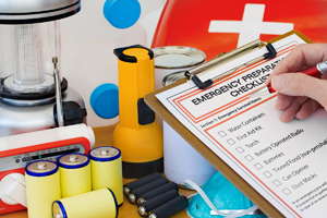 Emergency Prep check list and items hand with pen and clipboard